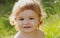 Child having fun on family picnic in summer garden. Baby face close up. Funny little child closeup portrait. Blonde kid