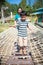 Child having fun at playground, mother near by. Happy asian family on vacation.