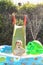 Child having fun playing in water in a garden paddling pool the boy is happy and smiling