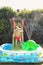 Child having fun playing in water in a garden paddling pool the boy is happy and smiling