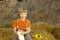 Child on haystack with bread and milk