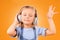 Child, headphones and dance to music in studio for freedom, multimedia subscription or kids podcast on orange background