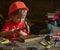 Child in helmet cute playing as builder or repairer, repairing or handcrafting. Toddler on busy face plays at home in