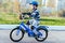 A child in a helmet and protection in a bike ride on nature in the spring