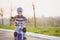 A child in a helmet and protection in a bike ride on nature in the spring