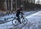 A child in a helmet rides a Bicycle in a winter Park