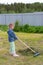 The child helps to remove the mown grass from the field.