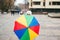 Child hiding behind colorful umbrella. Kid walking at city street during rain