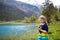 Child hiking in flower field at mountain lake