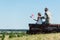 Child holding american flag near father in military uniform while sitting in fence