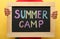 Child holding blackboard with words SUMMER CAMP