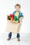 Child holding cardboard box packed with toys