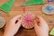 Child is holding a Christmas ball in his hands. Child is showing a Christmas ball. Easy recycled crafts and activities for kids