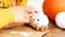 Child holding and decorating little white halloween pumpkin. Hands close up, cropped shot.