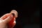 Child holding euro coin in his hand. Pocket money stock image. Poor low income group. Dark background. - Image. Close up