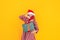 Child holding large boxes with gifts. There is a Santa hat on her head, and a medical mask on her face. Christmas mood. A perfect