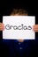 Child holding sign with Spanish word Gracias - Thank You