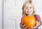 Child holding a small pumpkin