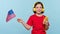 Child holding USA flag and smartphone