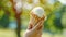 Child holding vanilla butter ice cream in waffle cone at park, summer sweetness