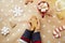 Child holds Christmas homemade gingerbread cookies among festive Christmas decorations with hot drink and marsmallows