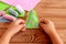 Child holds a felt Christmas tree in his hands. Green felt fur tree decorated with pink and blue balls