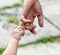 Child holds the finger of a hand of the father