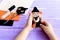 Child holds a Halloween witch doll in his hands and shows it. Scissors, thread, needle, felt on a wooden table. Creative witch