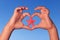 Child holds hands up to sky in the shape of a heart with starfish. Love shape child hands with starfish.