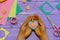 Child holds a heart shaped pendant in his hands. Child made a heart shaped pendant from felt, beads and buttons. Cute cheap gift