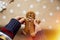 Child holds homemade gingerbread cookie on basic dots background. Festive Christmas atmosphere, home coziness and warmth