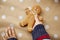Child holds homemade gingerbread cookie on basic dots background. Festive Christmas atmosphere, home coziness and warmth