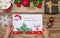 A child holds a letter to Santa Claus at the North Pole in Lapland, children`s hands on a wooden background with decorations and C