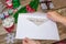 A child holds a letter to Santa Claus at the North Pole to Lapland, children`s hands on a wooden background with decorations