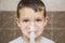 Child holds a mask vapor inhaler. Child who got sick by a chest infection after a cold or the flu that has trouble breathing and