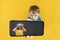 child holds the phone in his hand for advertising on a yellow background. Color