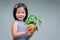 Child holds plant that has been planted in pot. Isolated background. Sweet smiling kid. Concept of saving the world.