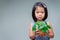 A child holds a tree planted in a pot made of coconut shells. Empty space to enter text