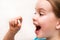The child holds a white oval tablet in his hand and wants to swallow it with joy. Medicines and synthetic vitamins