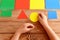 Child holds a yellow cardboard circle in his hands and puts on a corresponding color card. Child learns colors