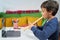 Child at home learning to play the flute with an online teacher connected with the laptop