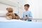 Child in hospital room playing with a sphygmomanometer and a teddy bear imitating doctor