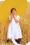 Child in a huge yellow hat in a wheat field in summer