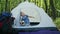 child indulges in a tent, summer family vacation in the forest.