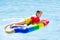 Child on inflatable float in swimming pool.