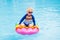 Child on inflatable float in swimming pool.