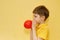 Child inflates a red balloon.