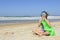 Child inflating inflatable swim ring on the beach