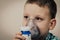 Child inhales couples containing medication to stop coughing. Medical procedure inhalation. Toddler with Respiratory disease