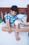 Child injured. Mother bandaging son\'s knee.